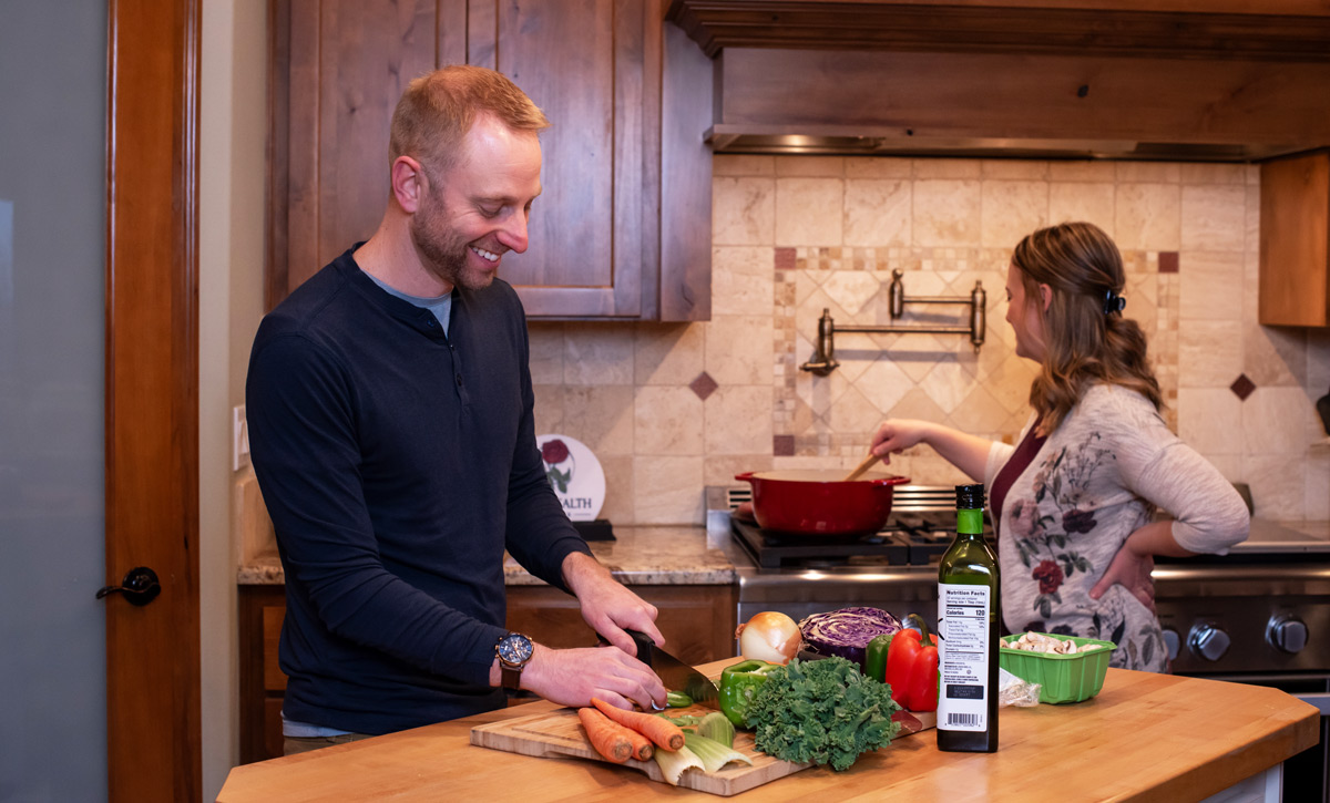 couple in the kitchen cutting vegetables